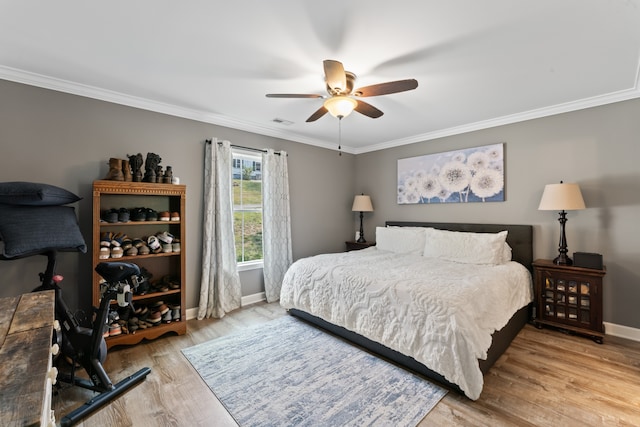 bedroom featuring ceiling fan, crown molding, and wood-type flooring