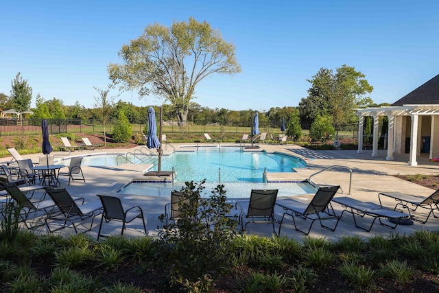 pool with a patio, a pergola, and fence