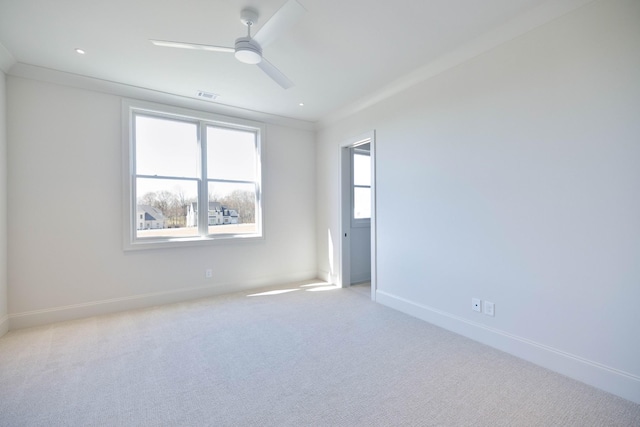 carpeted empty room featuring visible vents, ceiling fan, crown molding, and baseboards