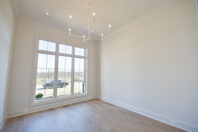 unfurnished room featuring visible vents, baseboards, a chandelier, ornamental molding, and wood finished floors