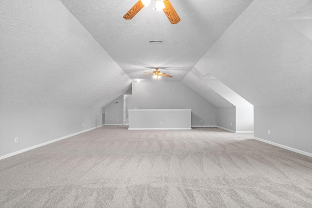 additional living space with baseboards, carpet, a ceiling fan, and a textured ceiling