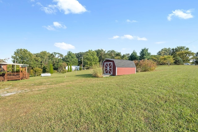 view of yard featuring an outdoor structure, a deck, and a shed
