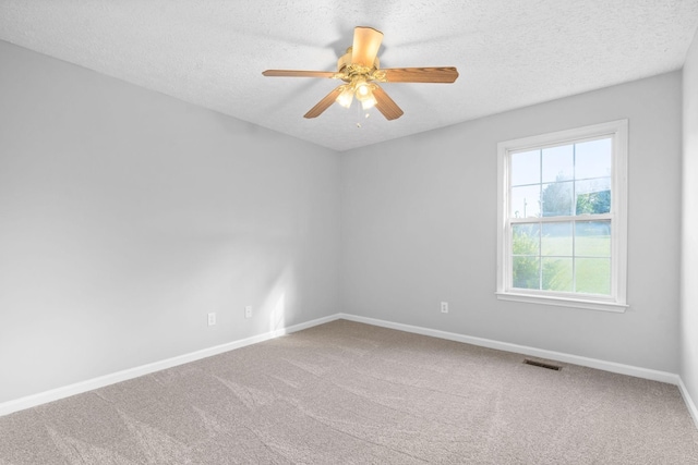 empty room featuring visible vents, baseboards, ceiling fan, a textured ceiling, and carpet flooring