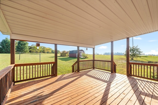 wooden deck with a yard, an outbuilding, and a shed