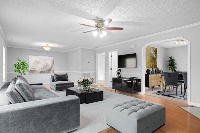 living area featuring a textured ceiling, ceiling fan, and wood finished floors