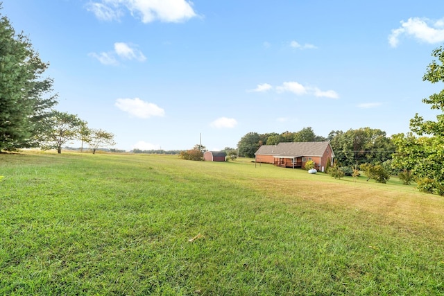 view of yard with an outdoor structure, a shed, and a rural view