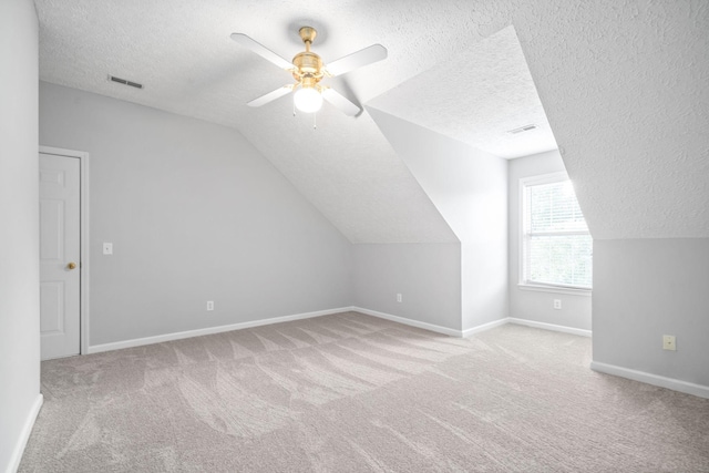 additional living space with visible vents, carpet flooring, and a textured ceiling