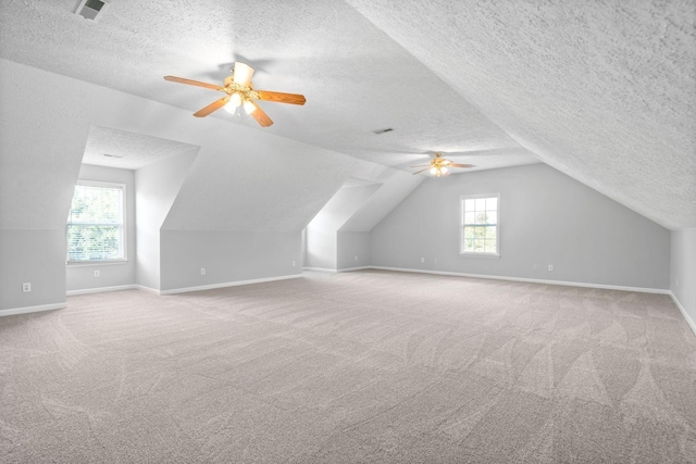 bonus room featuring carpet floors, ceiling fan, vaulted ceiling, and a textured ceiling