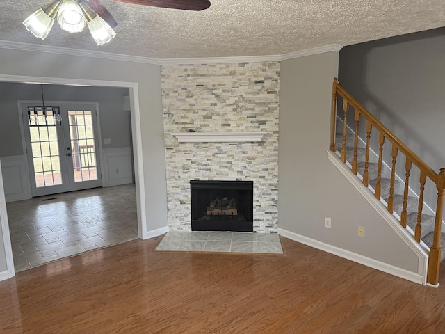 unfurnished living room featuring a textured ceiling, ceiling fan, and wood finished floors