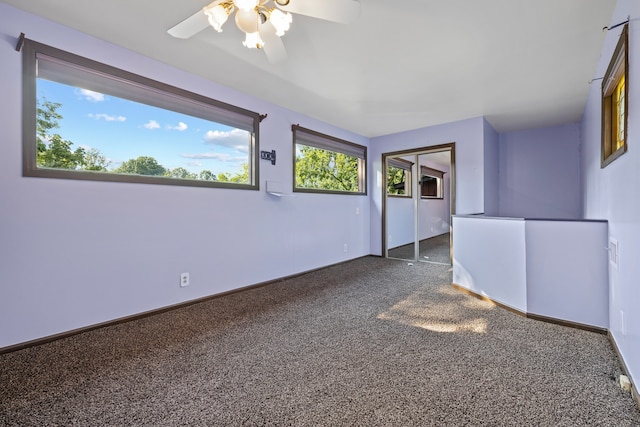 empty room featuring dark colored carpet and ceiling fan