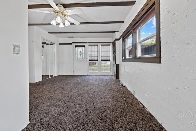 carpeted empty room featuring ceiling fan and beamed ceiling