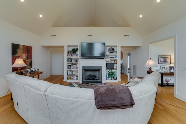 living room featuring light wood-type flooring and high vaulted ceiling