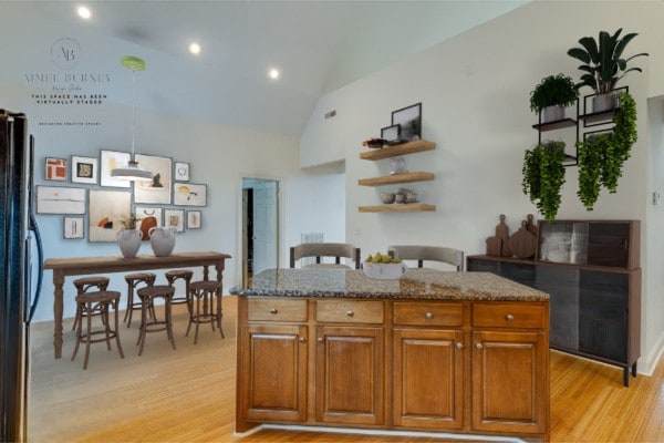 kitchen with stainless steel fridge, vaulted ceiling, a center island, and light hardwood / wood-style flooring