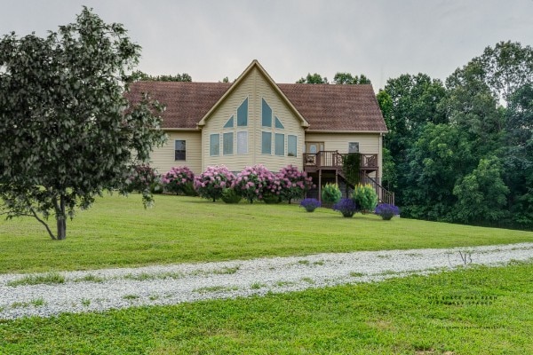 view of front of property featuring a front lawn and a deck