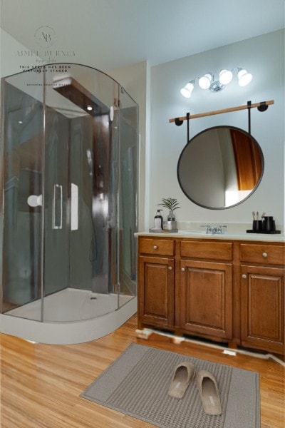 bathroom with a shower with shower door, wood-type flooring, and vanity