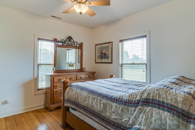 bedroom with multiple windows, ceiling fan, and light hardwood / wood-style floors