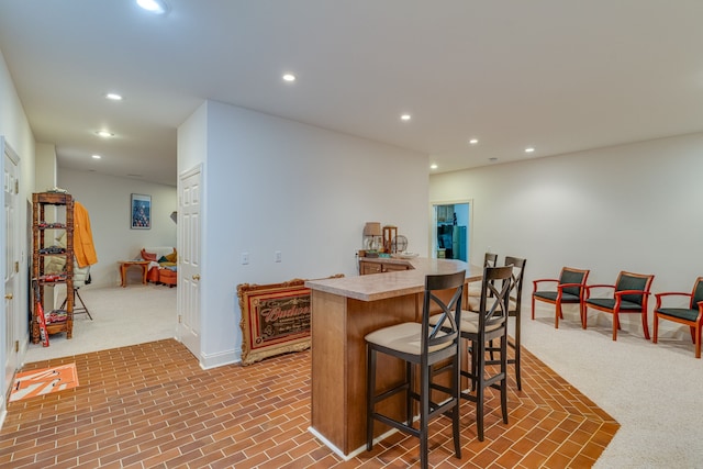 kitchen with a breakfast bar area and carpet floors