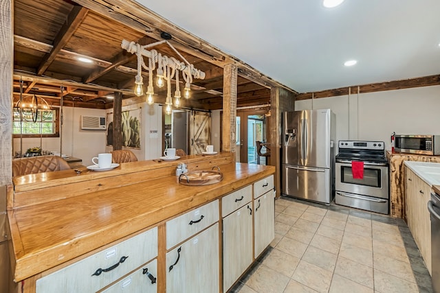 kitchen with decorative light fixtures, light tile patterned floors, stainless steel appliances, and wood counters