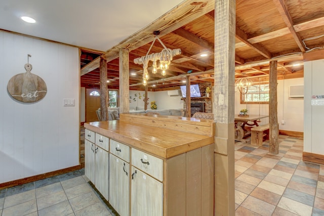 kitchen featuring a healthy amount of sunlight, wooden counters, hanging light fixtures, and a fireplace