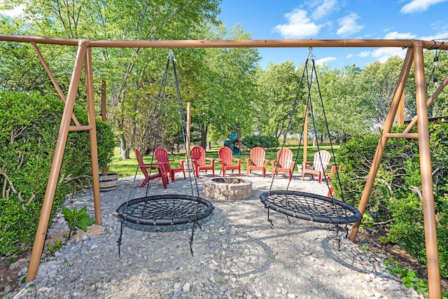 view of playground with a patio area and an outdoor fire pit