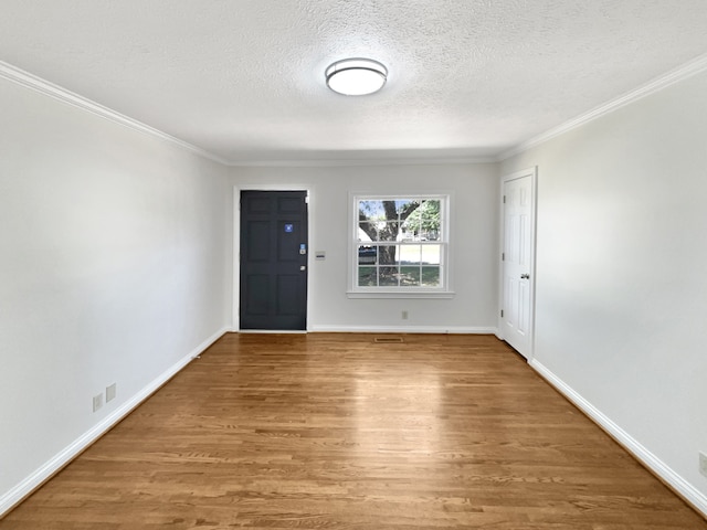 foyer featuring a textured ceiling, crown molding, and hardwood / wood-style floors