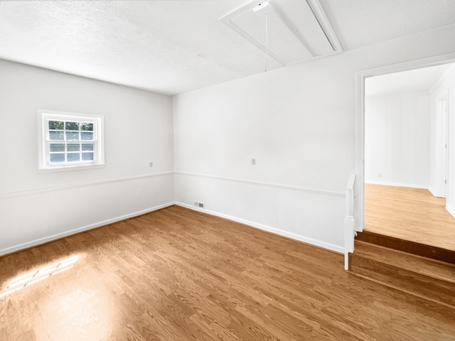 spare room with hardwood / wood-style flooring and a textured ceiling