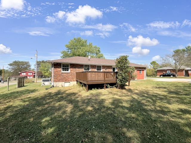 rear view of house with a deck and a lawn