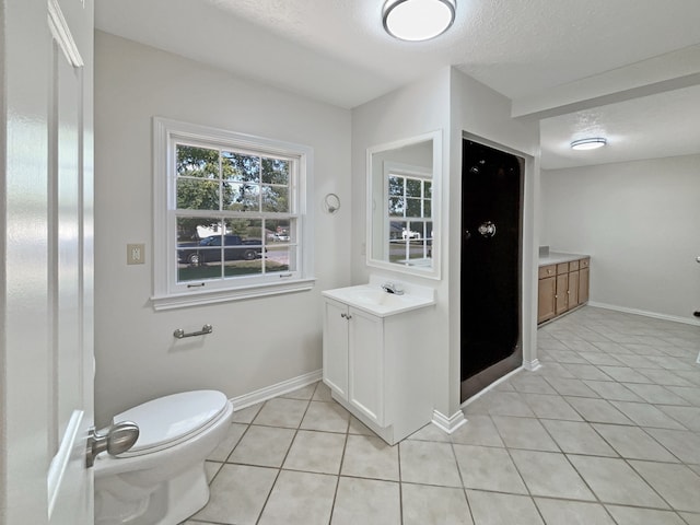 bathroom with tile patterned flooring, vanity, toilet, and a textured ceiling