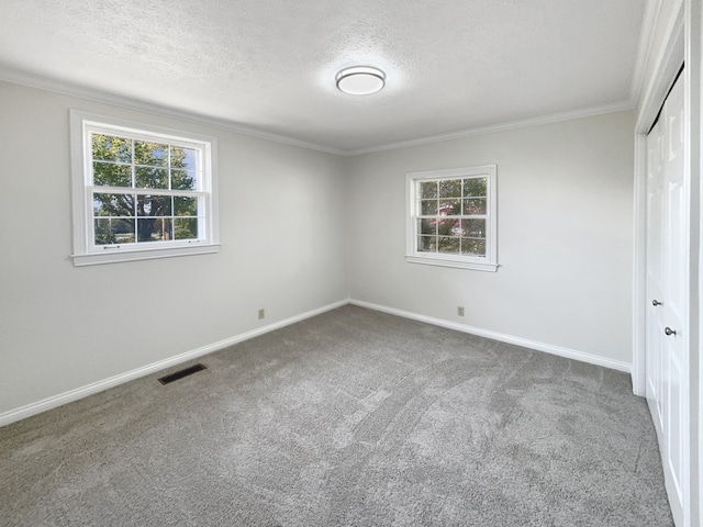 unfurnished bedroom with a closet, carpet, crown molding, and a textured ceiling