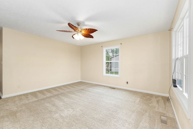 carpeted spare room with ceiling fan