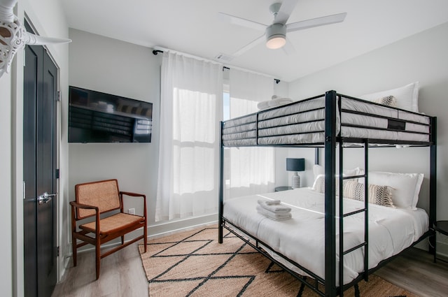 bedroom with ceiling fan, hardwood / wood-style floors, and multiple windows