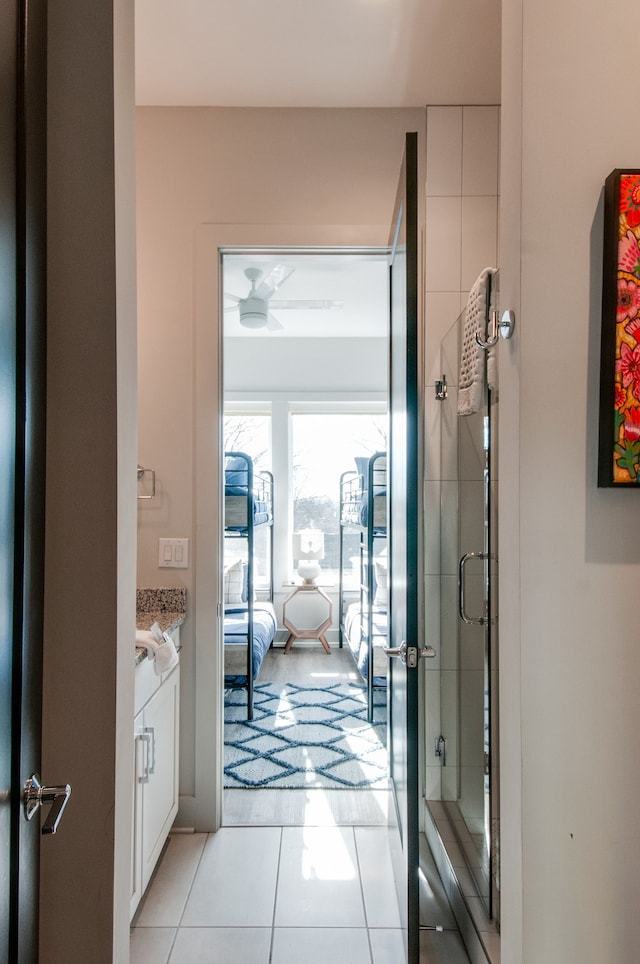 bathroom featuring tile patterned flooring, a shower with door, and vanity