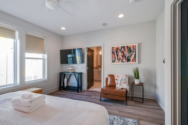 bedroom with dark hardwood / wood-style flooring, ensuite bathroom, and ceiling fan