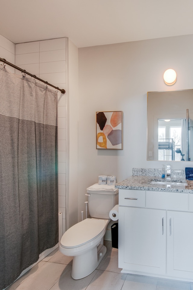 bathroom with tile patterned floors, walk in shower, toilet, and vanity