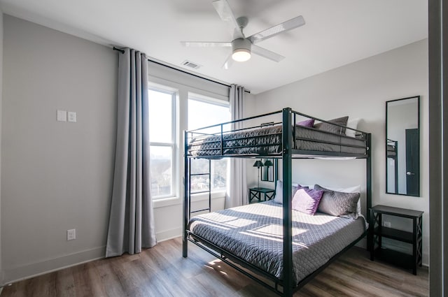 bedroom featuring multiple windows, hardwood / wood-style floors, and ceiling fan