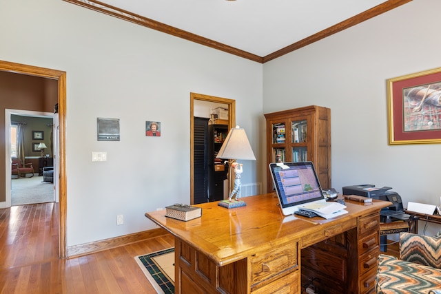 office area with light wood-type flooring and crown molding