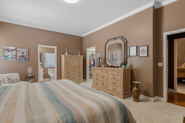 carpeted bedroom featuring ensuite bath, ornamental molding, a spacious closet, and a closet