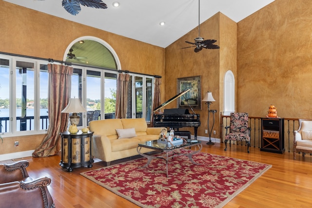 living room with ceiling fan, hardwood / wood-style floors, and high vaulted ceiling