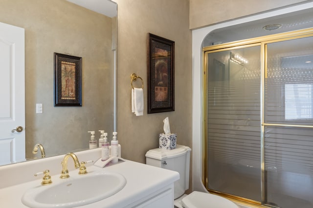 bathroom featuring vanity, toilet, and an enclosed shower