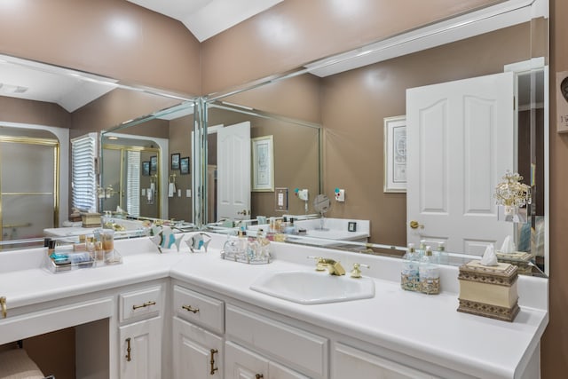 bathroom featuring lofted ceiling, a shower with door, and vanity