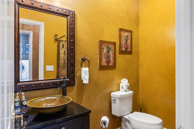 bathroom featuring washer / clothes dryer, vanity, and toilet