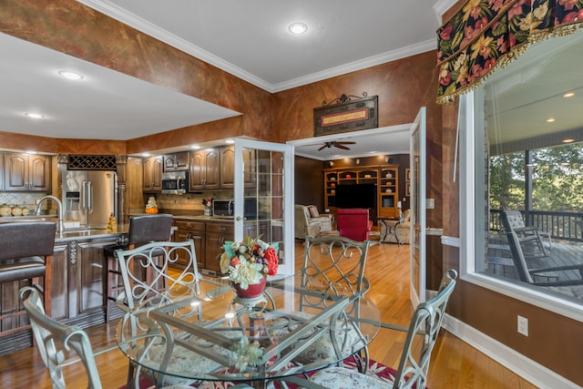 dining area featuring crown molding, ceiling fan, and light hardwood / wood-style flooring