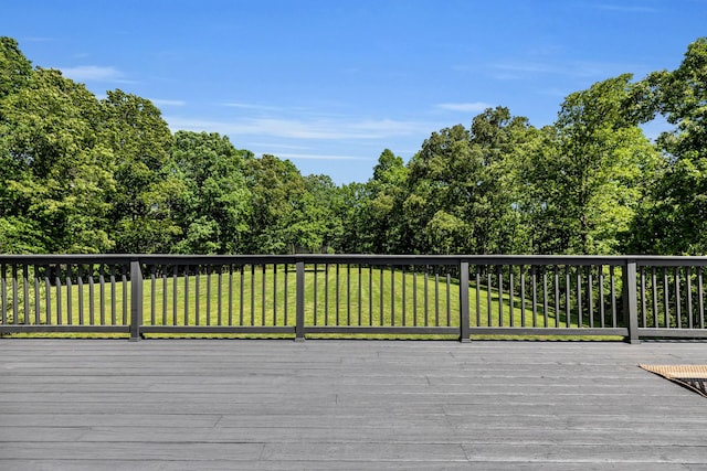 wooden deck featuring a lawn