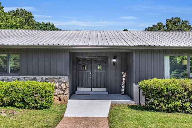 view of exterior entry with a yard