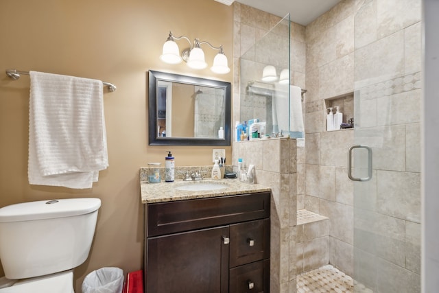 bathroom featuring vanity, toilet, and a shower with door