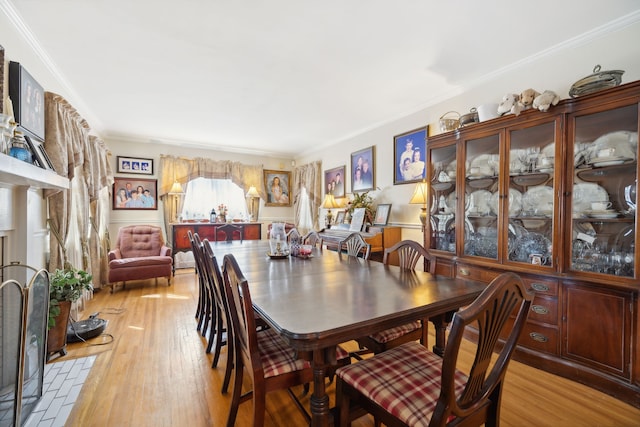 dining area featuring ornamental molding and light hardwood / wood-style floors