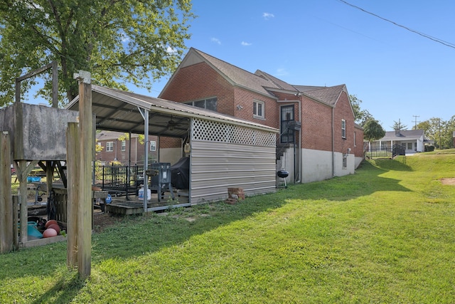 rear view of property featuring a yard and a wooden deck