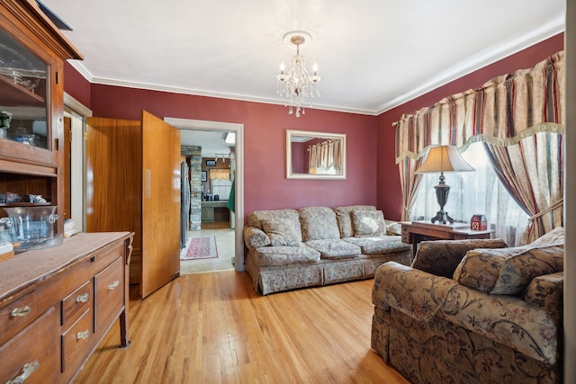 living room featuring crown molding, a notable chandelier, and light hardwood / wood-style floors