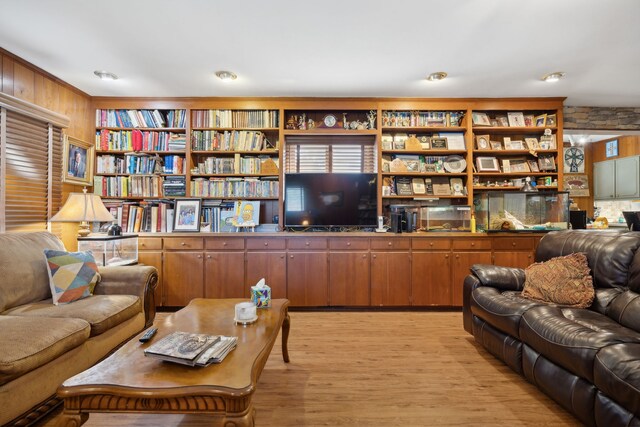 living room with wooden walls and light hardwood / wood-style floors
