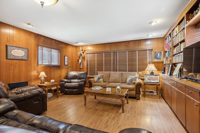 living room with light hardwood / wood-style flooring and wood walls
